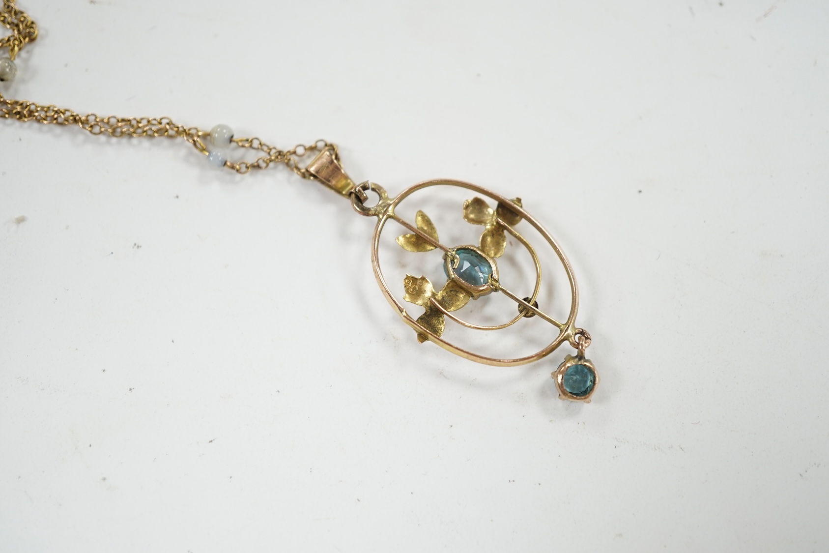 An Edwardian 9ct and gem set drop pendant, 39mm, on a later 9ct and simulated pearl set chain, 42cm. Condition - poor to fair